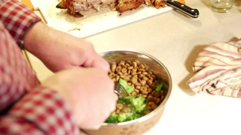 Man adding broccoli to dog food Stock Footage 38598399