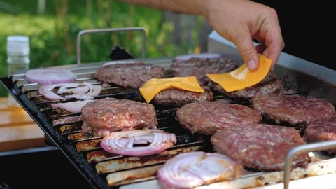 Man adding cheese on a burger Outdoors Stock Footage 85861449