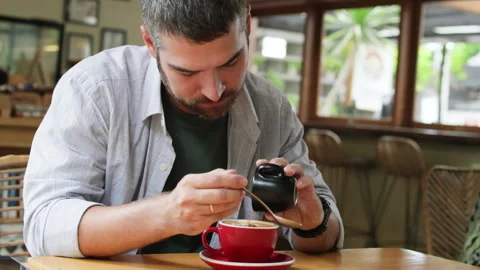 Man adding cinnamon in coffee. Stock Footage 272583612