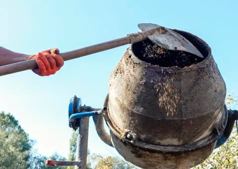 Man adding components to a cement mixer Foto stock