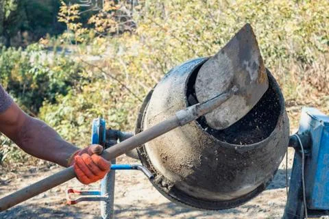 Man adding components to a cement mixer Foto stock