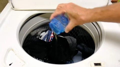 Man adding detergeant to washing machine Stock Footage 138600063