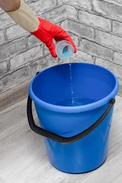 Man adding detergent to a bucket of water Stock Photos