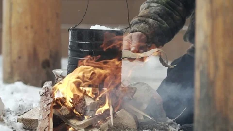 Man adding flakes of dry wood to lit the bonfire Stock Footage 79792121