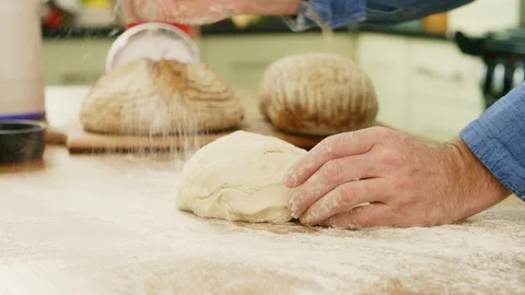 Man Adding Flour While Kneading Dough On Table Stock Footage 86116575
