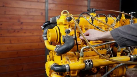 Man adding gas to an exposed boat engine in a workshop. High definition video. Stock Footage 88390273