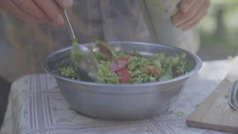 Man adding olive oil in fresh vegetables salad into bowl on tabletop Stock-Footage 251481338