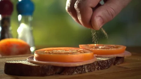 Man is adding some spices on the sandwich, close-up slow motion video Stock Footage 72493516