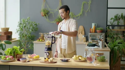 Man Adding Vegan Milk to Blender for Making Smoothie Stock Footage 231436416