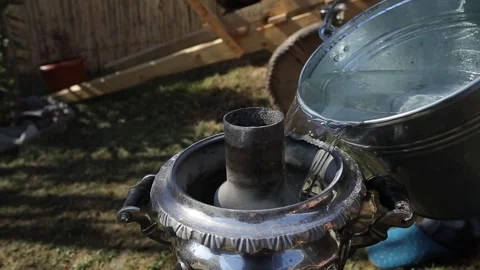 Man Adding Water to the Samovar with a Bucket Stock Footage 239329095