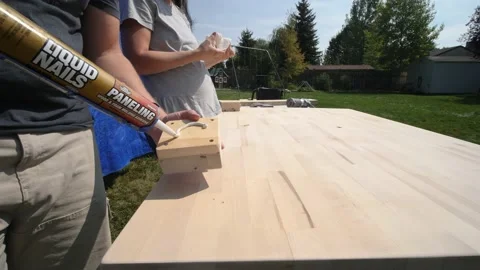 Man adding white adhesive to a block of wood Video stock 149133060