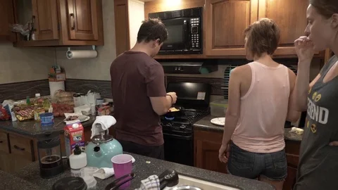 Man adds Cheese to Scrambled Eggs for Breakfast Stock Footage 80617889