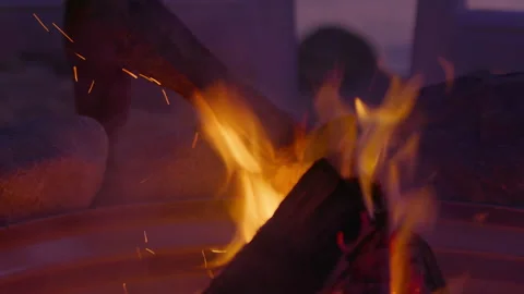 A man adds logs to a fire pit Stock Footage 161920937