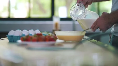 The man adds milk to the dish Stock Footage 79112074