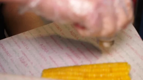Man adds salt to boiled corn on cob in street fastfood cafe Video stock 133403641