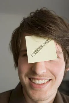 A man with an adhesive note on his forehead stamped 'Unemployed' Stock Photos