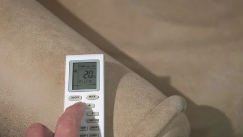 Man adjust temperature with remote indoor Stock Footage 303382947