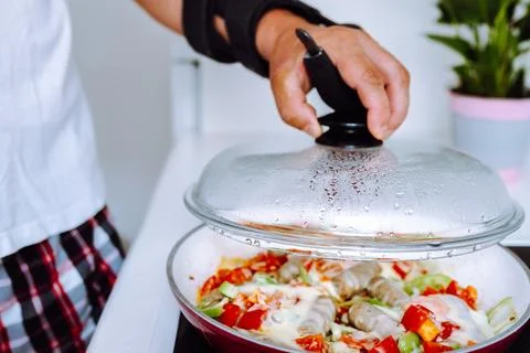 Man with adjustable elbow brace preparing food Stock Photos