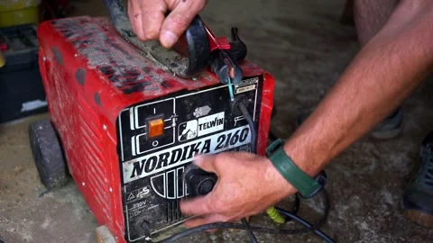 Man adjusting the amperage on a Telwin Nordika 2160 welding machine. Stock Footage 343101927