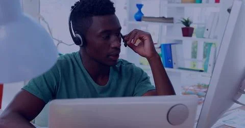 Man adjusting boom mic, causing data overlays intensifying over monitor while Stock Photos