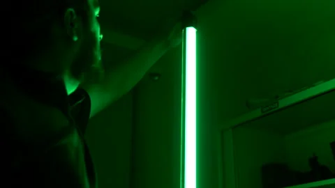 Man adjusting colorful studio LED light Stock Footage 316233991