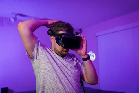 Man adjusting fit of VR headset before gaming Stock Photos