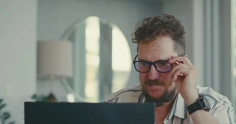 Man Adjusting Glasses While Using Laptop at Home 스톡 동영상 323587549