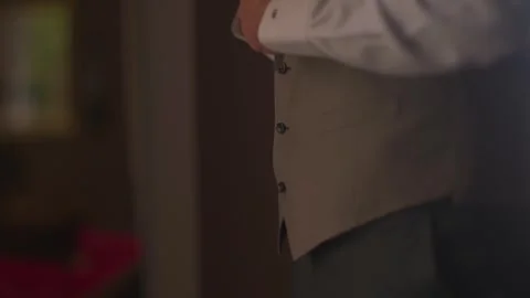 Man adjusting his formal vest and shirt cuffs for an elegant occasion Stock Footage 345260646
