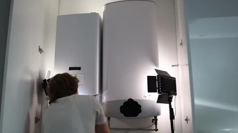 Man adjusting home boiler system and checking gas heater connections symbolizing Stock Footage 318868692