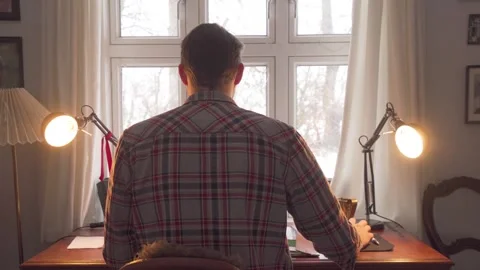 Man Adjusting Light Sitting on Working Desk In Front of a Window - Remote Video stock 261780316