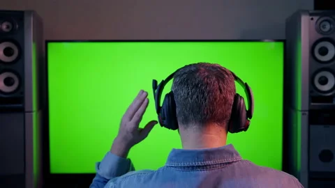 Man adjusting the mike on a headset while facing a blank screen Stock Footage 167168032