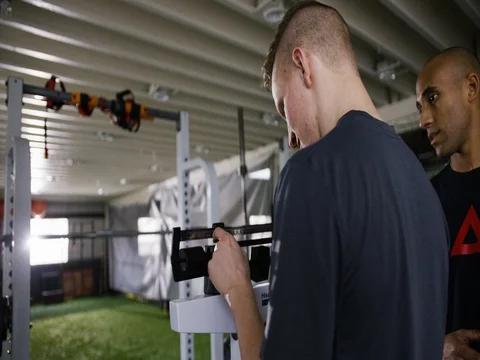 Man adjusting portable height measure with his trainer in fitness studio 動画素材 77493239