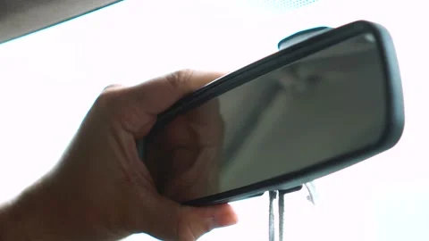 Man adjusting rearview mirror in car Stock Footage