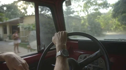 Man adjusting the steering wheel while driving on a country road Stock Footage 79791755