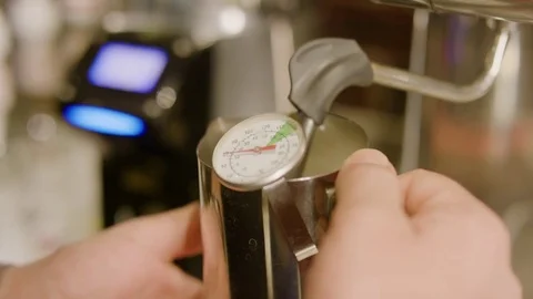Man adjusting the temperature of the milk for making coffee Stock Footage 76293949