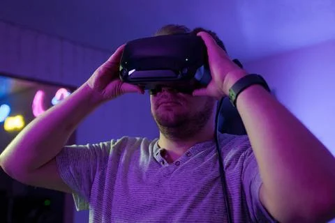 Man adjusting VR headset for immersive virtual experience Stock Photos