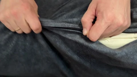 Man adjusting zipper on gray sofa cushion cover. Home furniture maintenance and 스톡 동영상 336978894