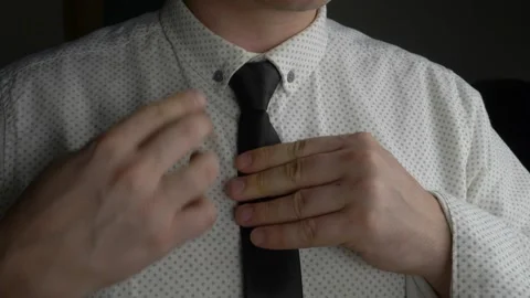 Man adjusts black tie on buttoned shirt Stock Footage 327282703