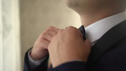 Man adjusts collar and bow tie Stock Footage 166921391