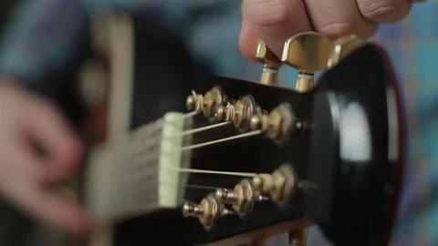 A man adjusts a guitar. Close-up Video stock 72720160