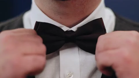 The man adjusts his bow tie with his hands. Close-up shooting Stock Footage 195098623