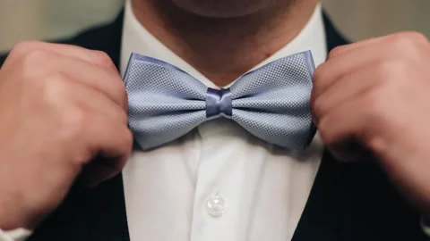 The man adjusts his bow tie with his hands. Close-up shooting Stock Footage 295890911