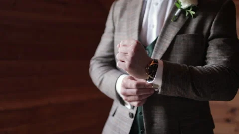 The man adjusts his cufflinks on the sleeves. Groom preparing for a wedding day. Stock Footage 201523939