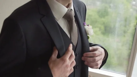 Man adjusts the lapels of his suit jacket Stock Footage