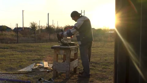 A man adjusts a miter saw 4K Stock Footage 294048848