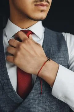 Man adjusts red tie with focused calmness Foto stock