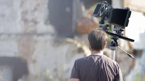 Man adjusts the retro camera among the ruins Stock Footage 71824808