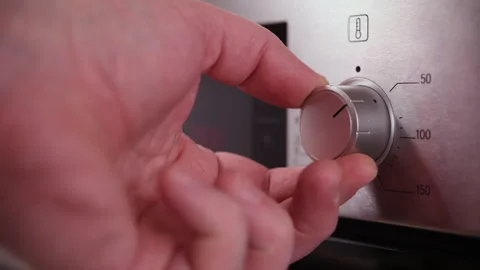 Man adjusts temperature and sets operating mode on modern oven in kitchen. Stock Footage 302668686