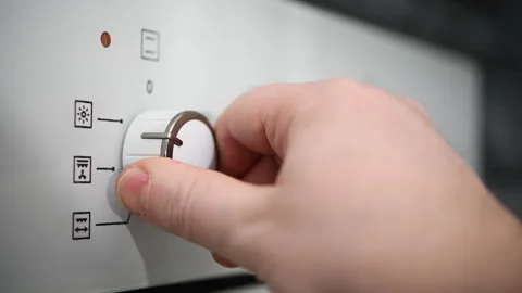 Man adjusts temperature and sets operating mode on modern oven in kitchen. Stock Footage 304896678