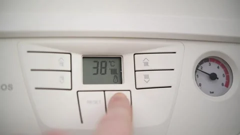 A man adjusts the temperature of a gas boiler in an apartment. Video stock 300081810